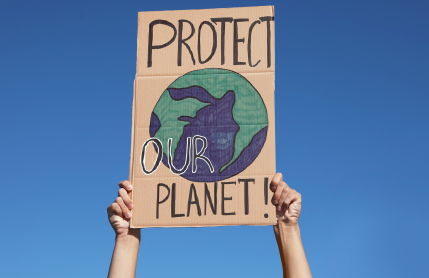 Image of someone holding up "prtect Planet" sign