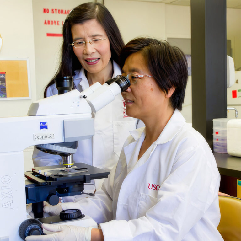 Doctor examining skin cells under a microscope