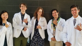 MD-PhD students giving the hang loose sign.