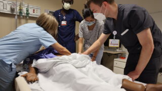 Residents practice clinical skills on workshop mannequin.