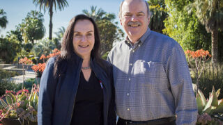 Zea Borok, left, and John Reith, chair of the board of the Hastings Foundation, are seen at the entrance to the Huntington Botanical Gardens.