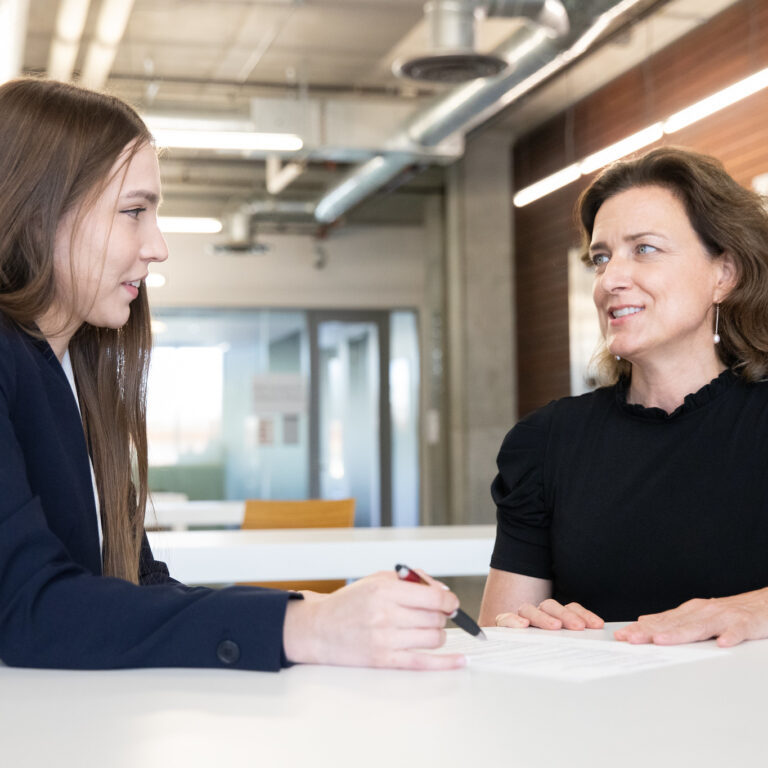 college student consults professor at table
