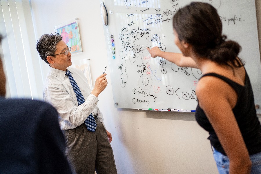 Faculty member at whiteboard with student