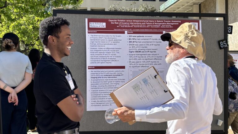 Judge and student talking and smiling in front of poster