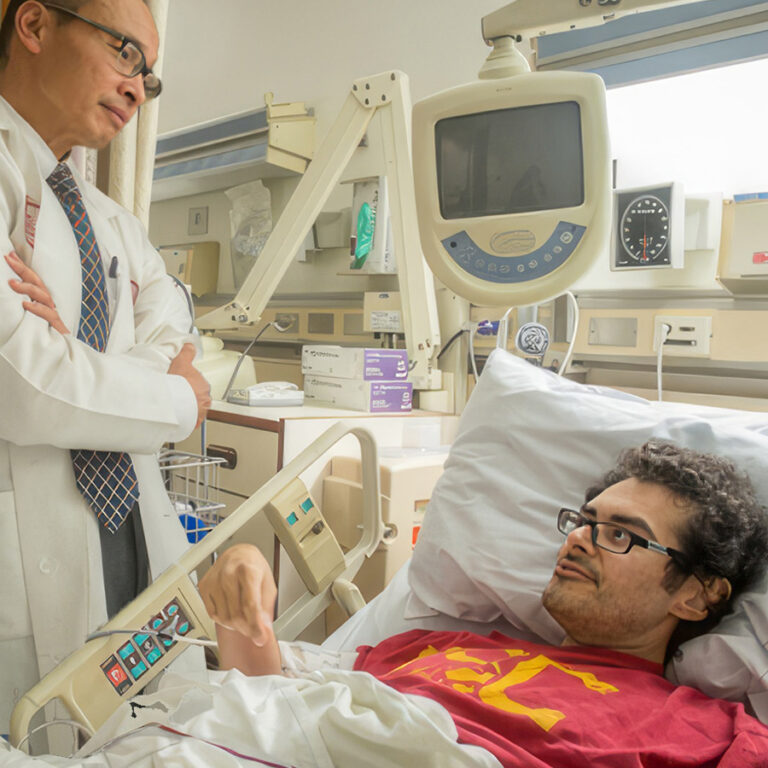 Physician standing next to the patient in bed, looking at each other
