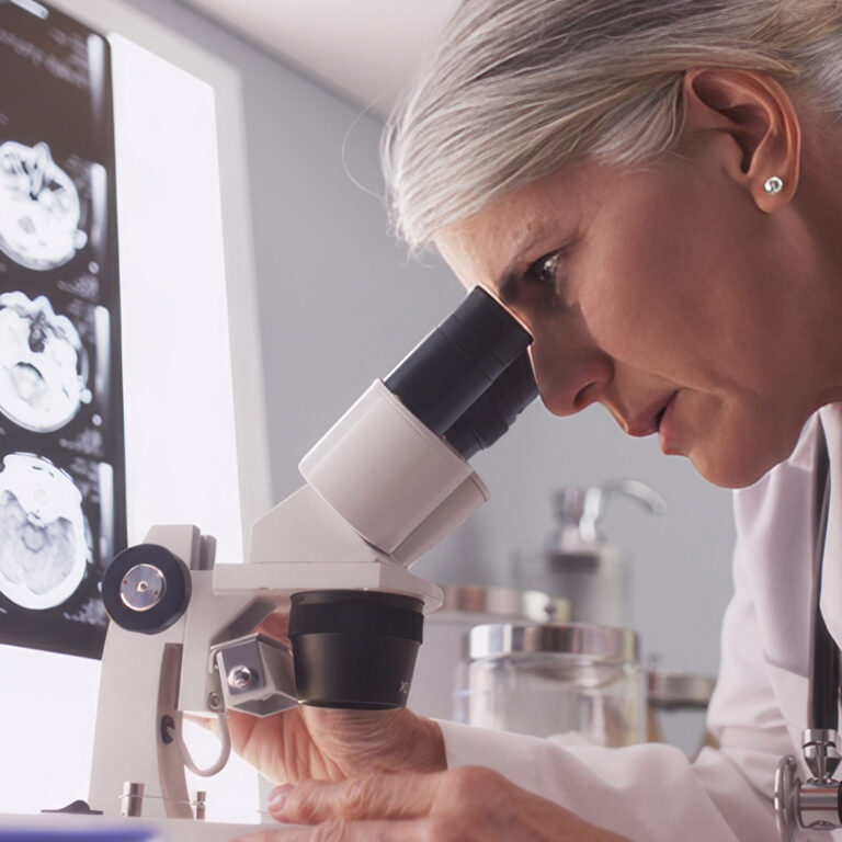 Doctor looking through microscope