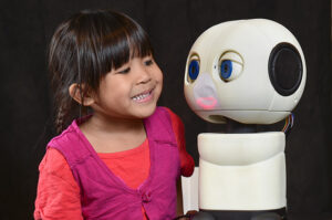 Stella Modina, 4, poses with Mki an interactive robot developed by USC's Viterbi School of Engineering, Robotics, to help children in medical and clinical situations, Wednesday, January 14, 2015. USC Photos/Gus Ruelas