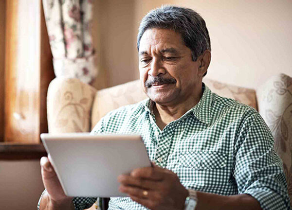 A man with Alzheimer's uses a tablet.