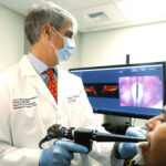 Michael Johns, MD., Diego Razura (CSTP medical student), and the Optical Coherence Tomography (OCT) system in action.