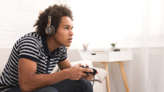 Male playing videogames with headphones on