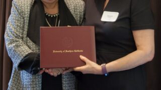 smiling woman being presented with award