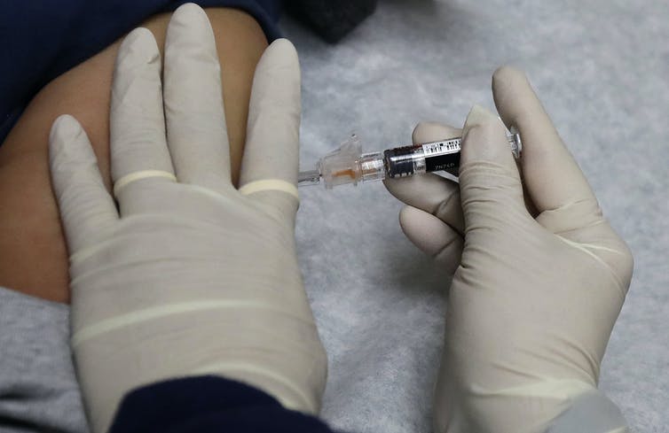 An arm being injected with a vaccine