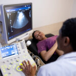 Photo shows a Hispanic pregnant woman having an ultrasound.