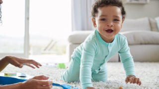 Mixed race mum and toddler son playing at home