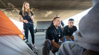 Image shows Brett Feldman and the USC Street Medicine team treating a patient.