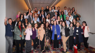 Donna Elliott, in the blue coat, celebrates with medical education colleagues.