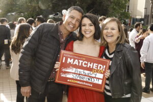 Student poses with her parents holding a sign that says I matched at Stanford in Psychiatry