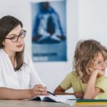 Photo shows teacher trying to work with a child who is not paying attention.