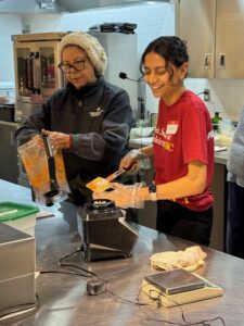 Student with community member in the kitchen cooking