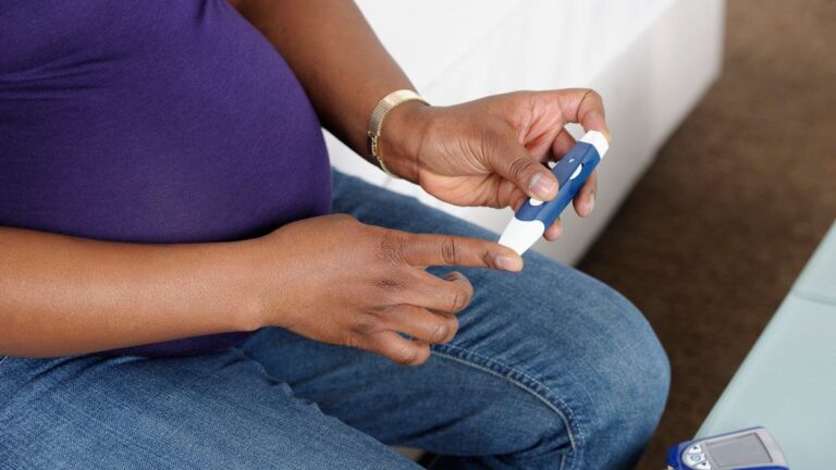 Photo shows pregnant woman testing her blood sugar.