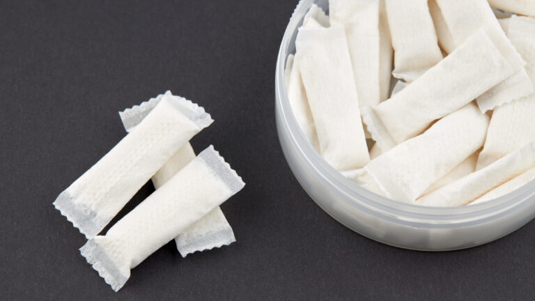 stack snus tobacco pouches over black background
