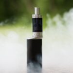 vape with smoke in front of greenery