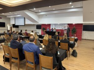 Dr. Warren Garner moderates a panel discussion as an audience looks on.
