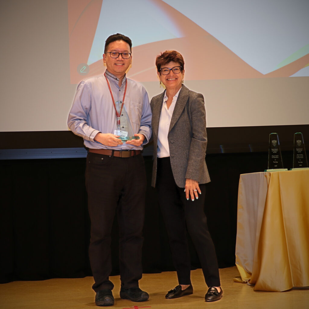 Charleston Chiang, PhD, on the left holding his trophy next to Dean Meltzer