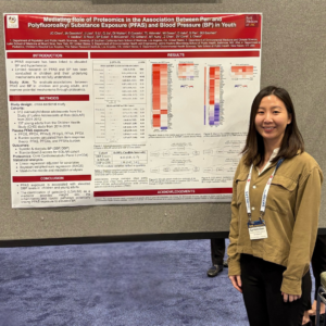 smiling researcher in front of poster
