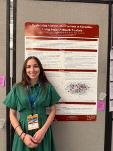 smiling woman in front of research poster