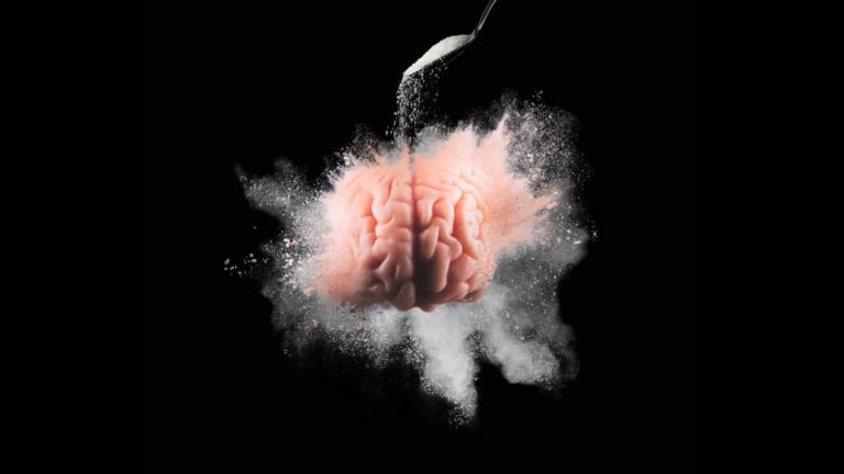 A close-up of a brain against a black background as sugar is poured from a teaspoon