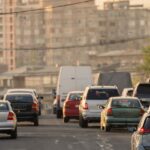Photo shows traffic near a large apartment complex.