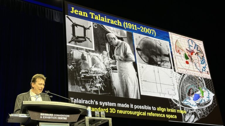 Photo shows Paul Thompson delivering the Talairach Lecture at OHBM 2025.