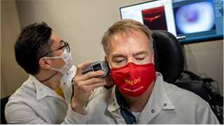 Researcher using optical coherance tomography (OCT) to see inside patient's ear for diagnosis. Photo Credit: Chris Shinn.
