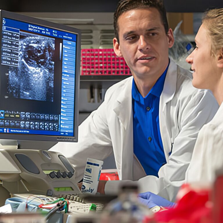 Two doctors having a conversation in front of a computer monitor