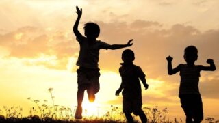 Children playing at sunset