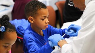 PA works with childrens,showing them how sutures are made.