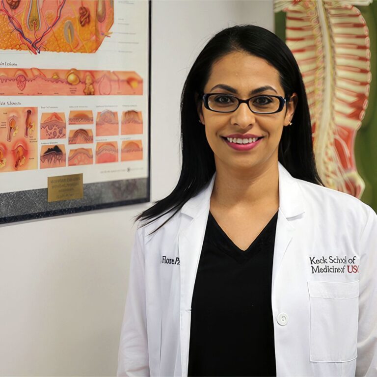 Smiling student in front of an anatomical chart.
