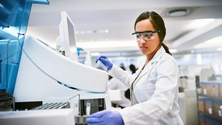 Postdoc operating a piece of lab equipment
