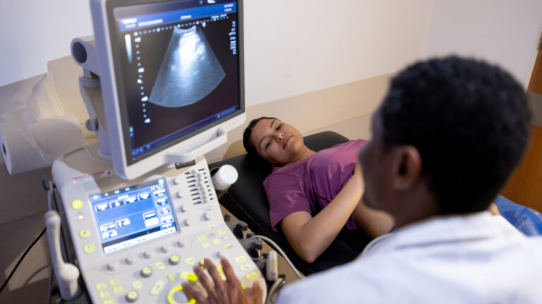 Photo shows a Hispanic pregnant woman having an ultrasound.