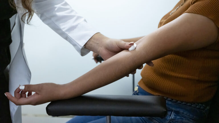 Nurse putting a cotton wool pad where draw blood