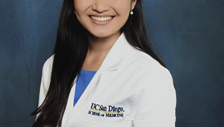 smiling medical student in white coat