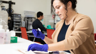Woman in blue gloves with a sample