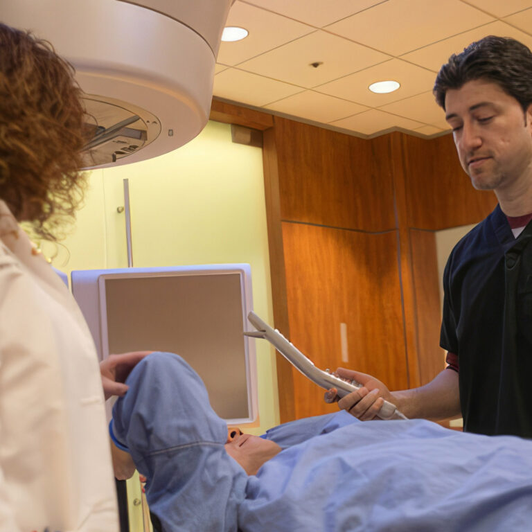 Staff perform procedure on a patient lying down