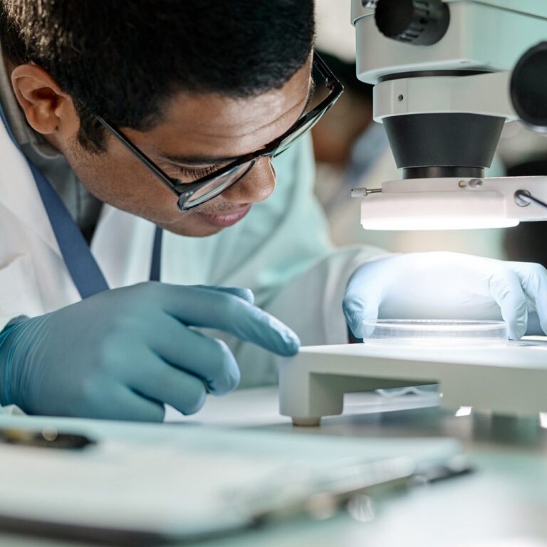 Researcher adjusts a slide under a high power microscope