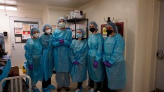 Faculty and students in blue scrubs