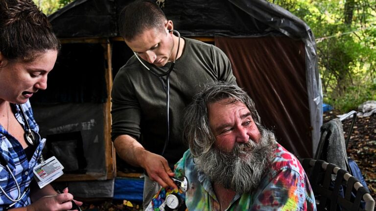 Video cover of Street Medicine staff attending to a patient in a tie-dye shirt.