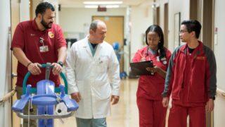 Neurologist walking in hallway with staff