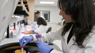 Researcher adding test to centrifuge